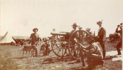 Pom pom gun crew. Ammunition carriers are standing to the left with the two dogs.