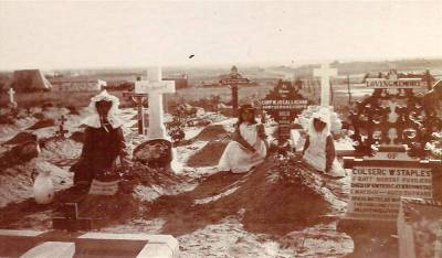 Mother and two daughters tending graves at Kroonstad.