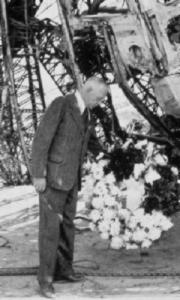 Lieutenant Colonel Joachim Breithaupt laying a wreath at the charred bow of the German airship 'Hindenburg,' Lakehurst, New Jersey, 1 May 1937.